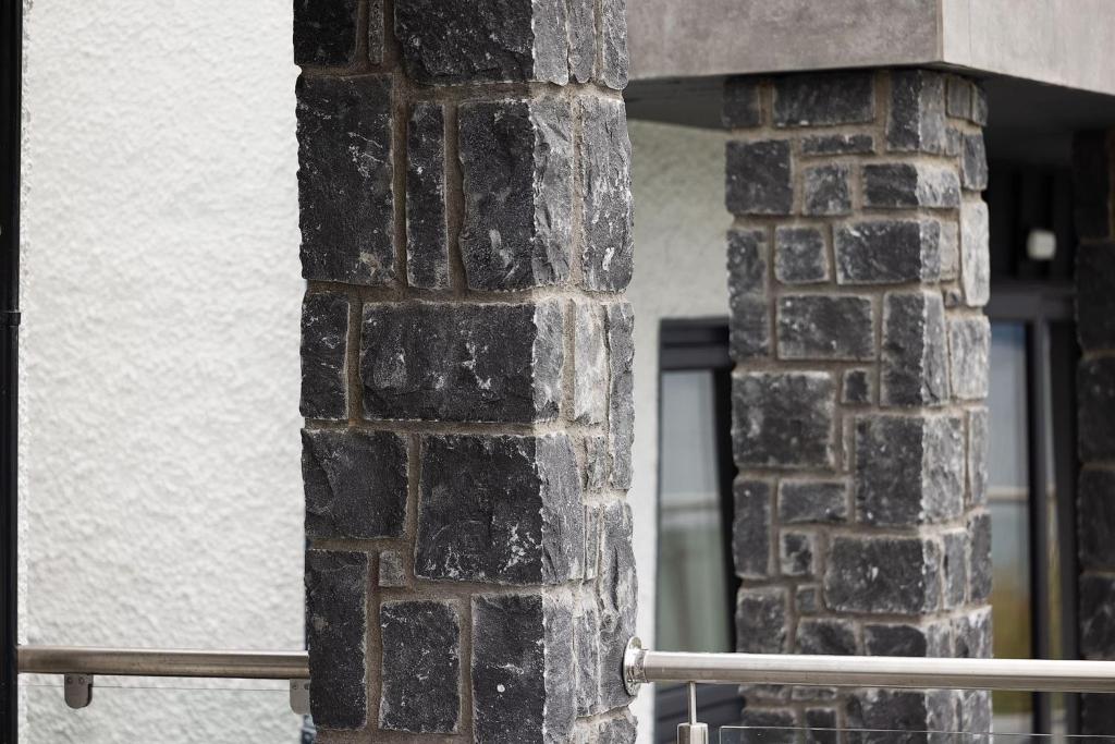a brick pillar of a building with a window at Pierside Apartments Deluxe Accommodation in Portsalon
