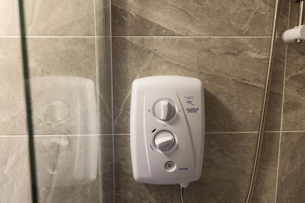 a soap dispenser on a wall in a bathroom at Pierside Apartments Deluxe Accommodation in Portsalon