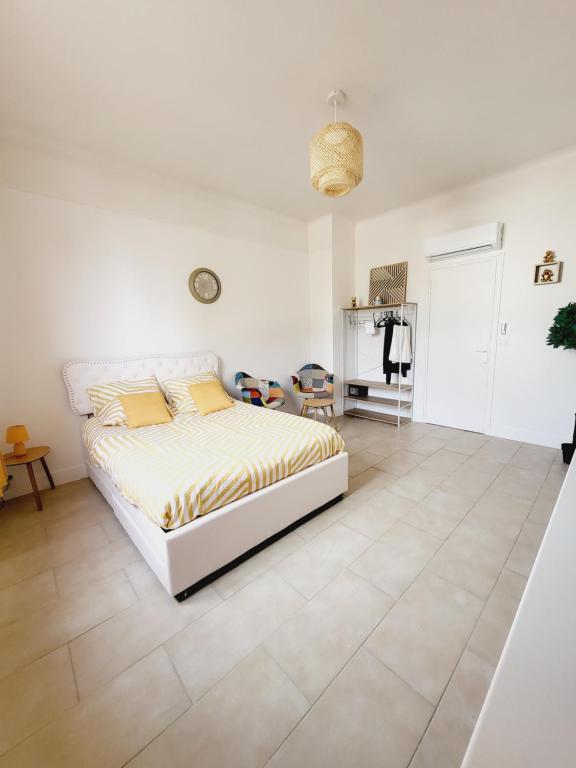a white bedroom with a bed and a tiled floor at Soleil in Itteville