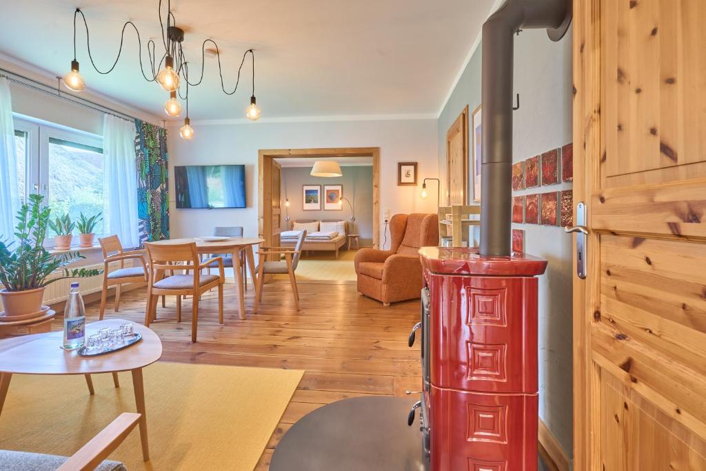 a kitchen and living room with a red stove at Familiennest am MüritzSee mit Kamin & Sauna in Sietow Dorf
