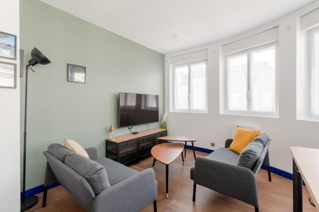Una sala de estar con dos sillas y un televisor. en "STUDY-HOME 44600" Apt d'exception 3 Etoiles, en Saint-Nazaire