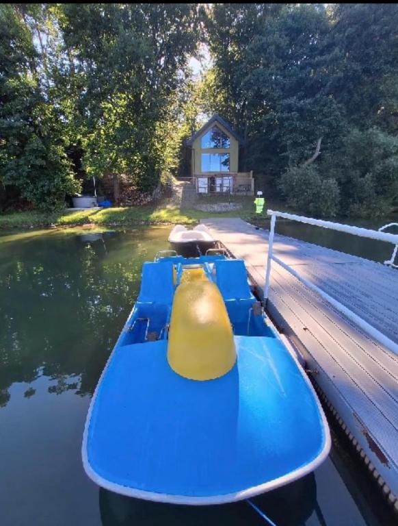 a blue boat with a yellow engine on the water at Jarski Domek in Stężyca