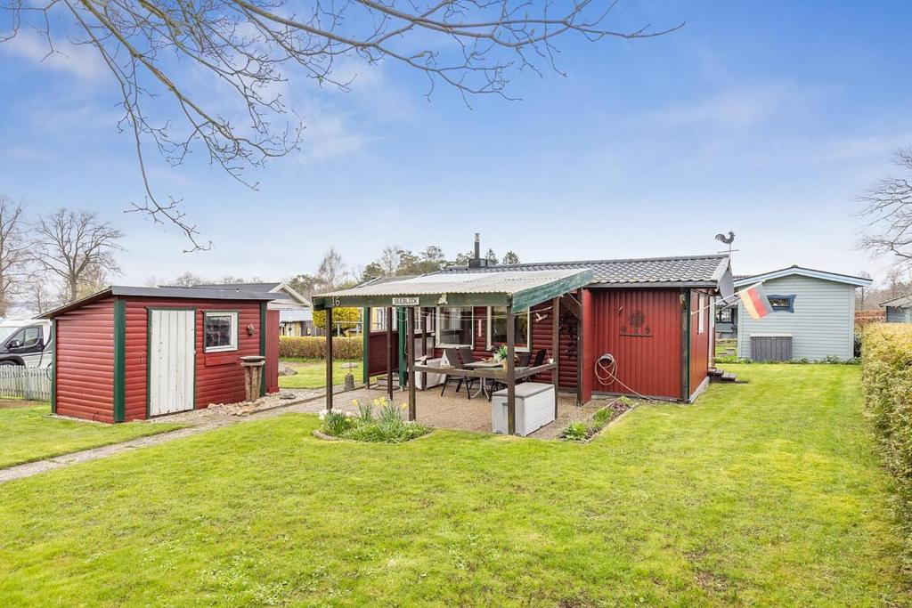 a home with a garden and a house at Stuga på ringsjös camping in Hörby