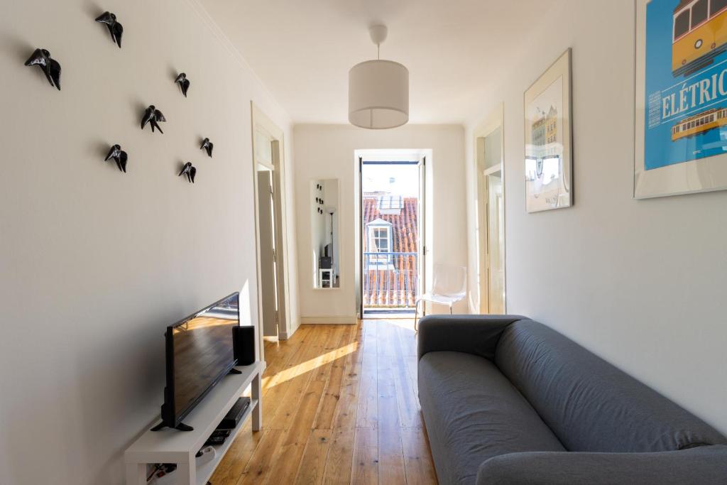 a living room with a couch and a tv at Casa dos Mastros in Lisbon