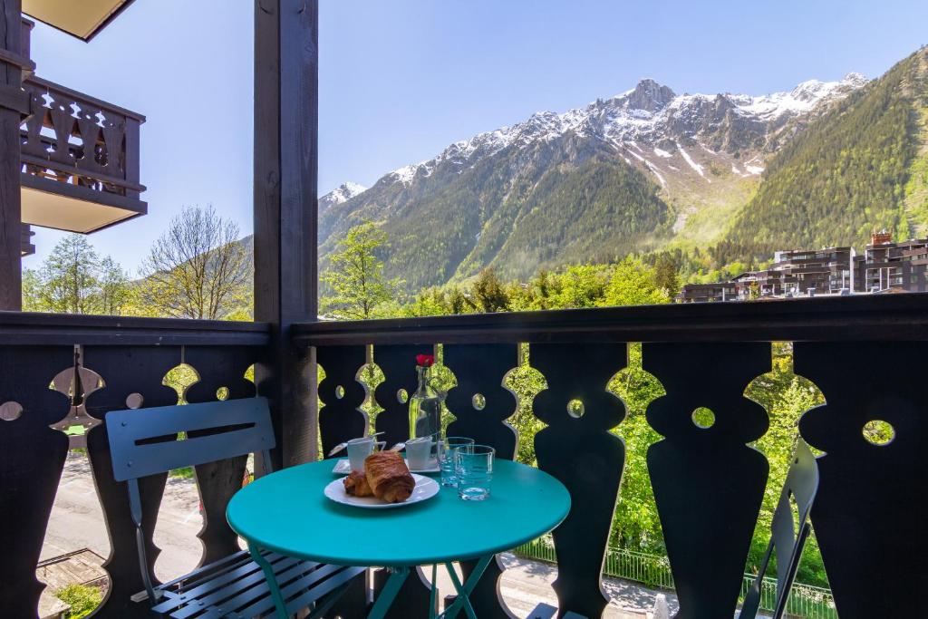 a table on a balcony with a view of mountains at Chamonix Sud - Forclaz 213 - happy Rentals in Chamonix-Mont-Blanc