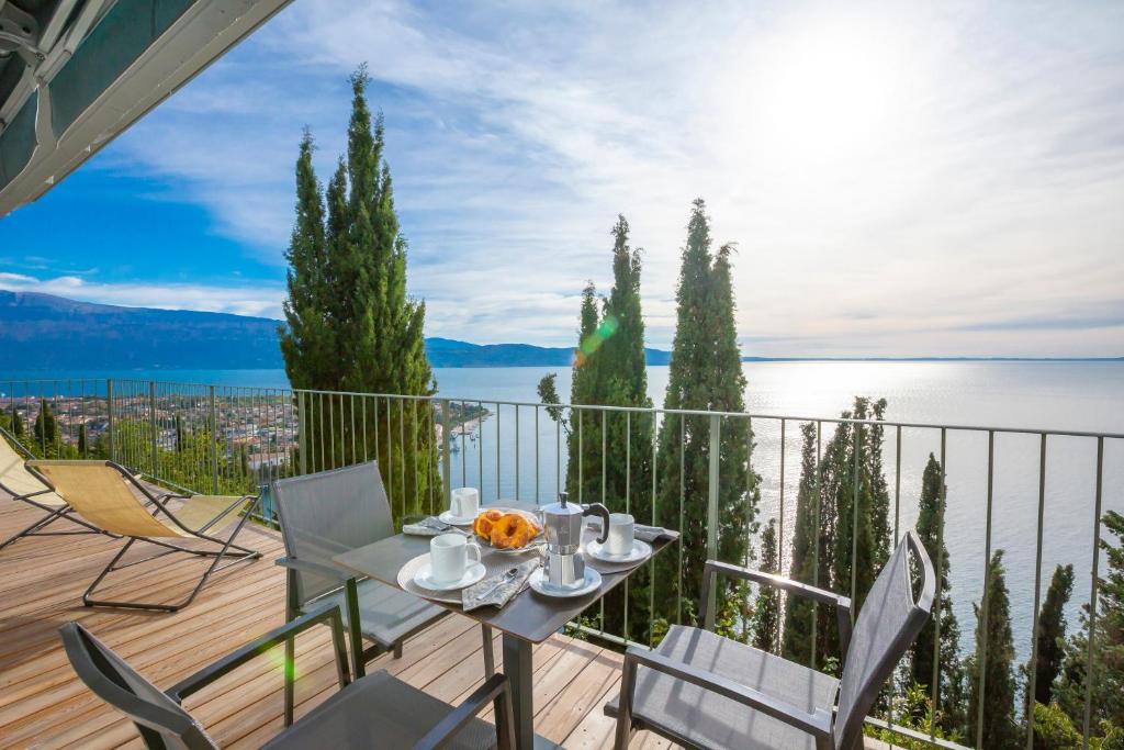 stół i krzesła na balkonie z widokiem na wodę w obiekcie Rustichel Fantastic Lake View - Happy Rentals w mieście Toscolano Maderno