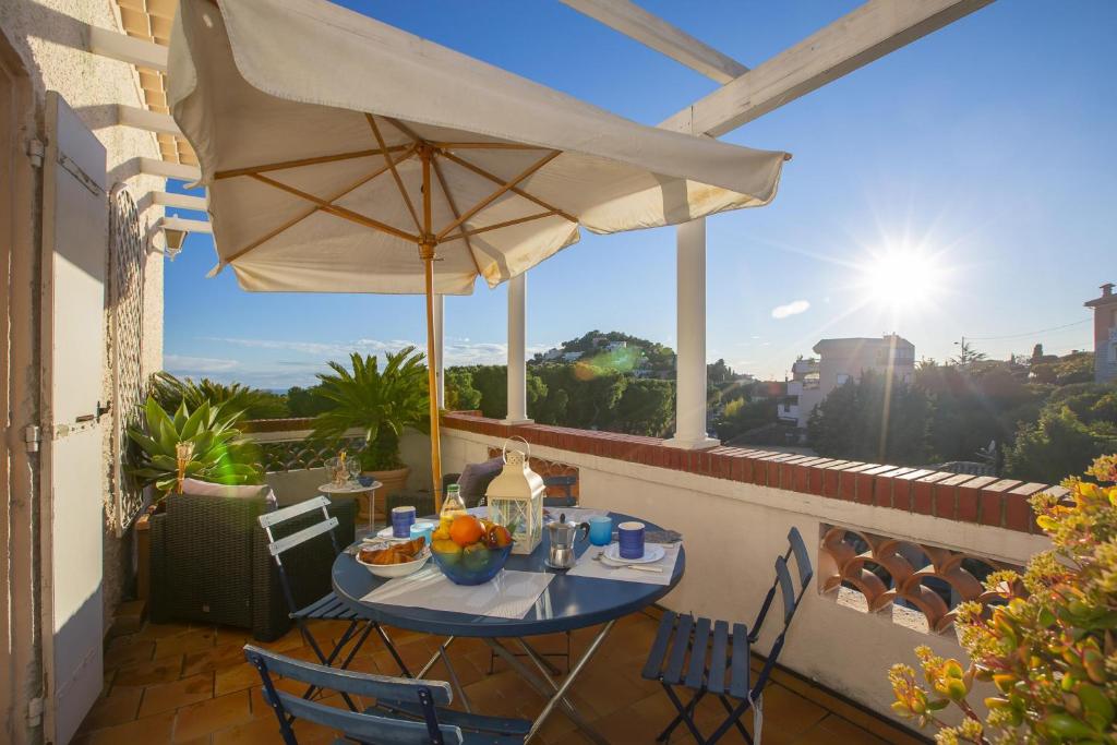a table with an umbrella on a balcony at Villa MonTLilin - Happy Rentals in Villefranche-sur-Mer