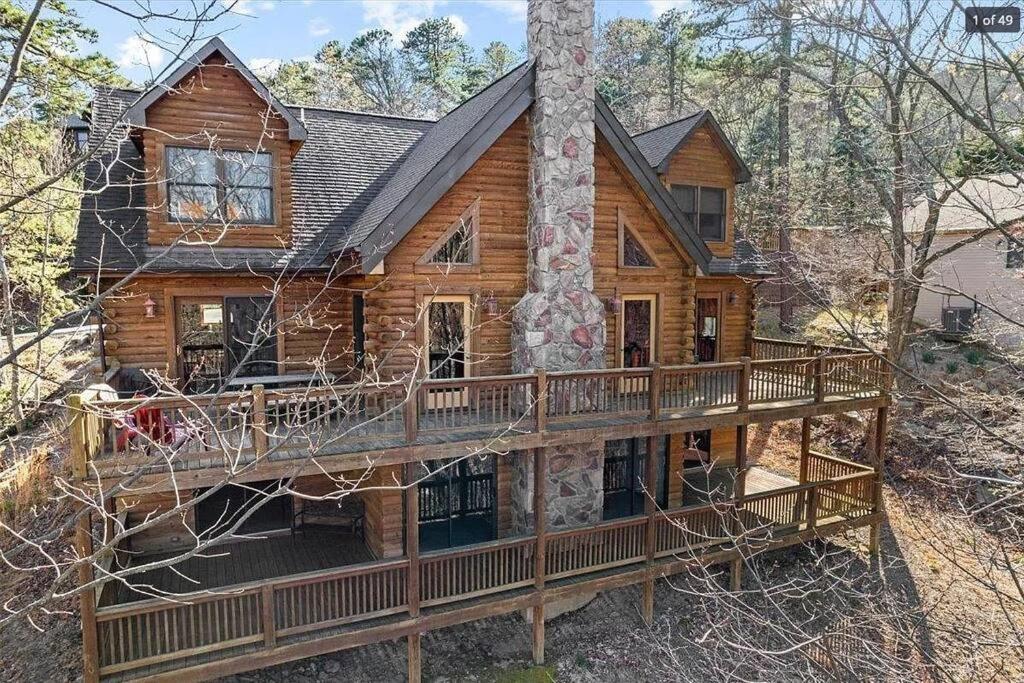 une cabane en rondins entourée d'une terrasse. dans l'établissement Awesome Log Cabin in Massanutten Resort, à McGaheysville