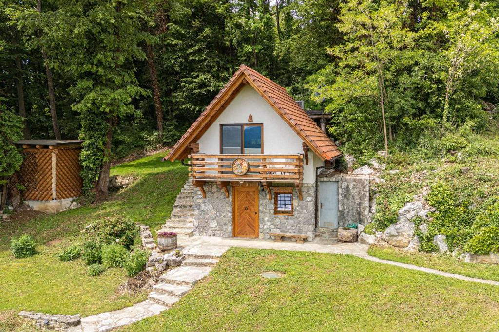 una pequeña casa con una puerta de madera en un patio en Vineyard Cottage Rataj 2 Wellness - Happy Rentals, en Novo Mesto
