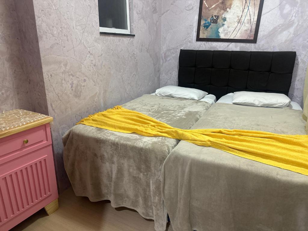 a bedroom with a bed with a yellow blanket on it at Hotel Pousada Irmaos Freyhardt in Rio de Janeiro