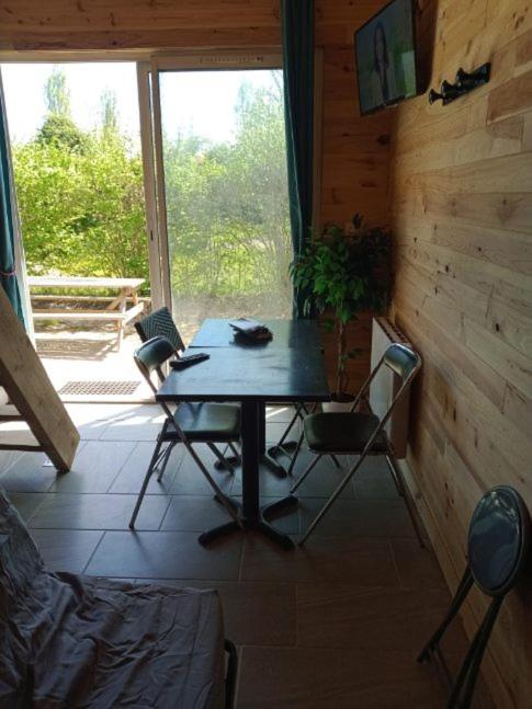 une salle à manger avec une table et des chaises dans une cabine dans l'établissement Chalet au calme, à Coullons