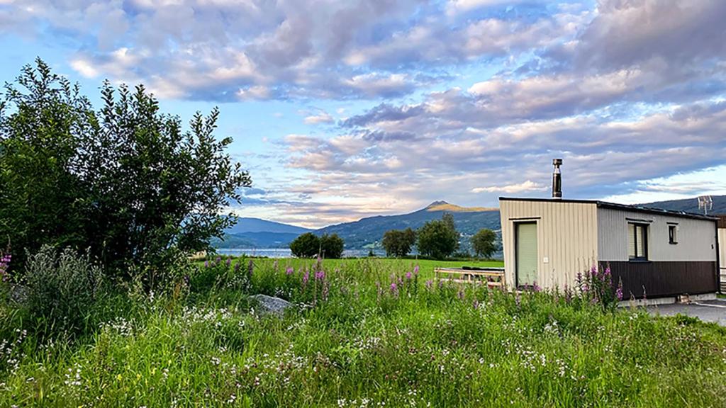 a small building in the middle of a field at Mjøsvang Kafe in Vang I Valdres