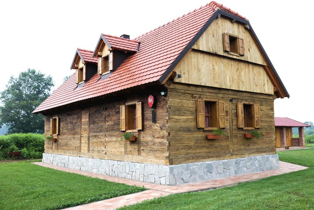 a large wooden house with a red roof at Holiday house Rustic Oak in Gospić