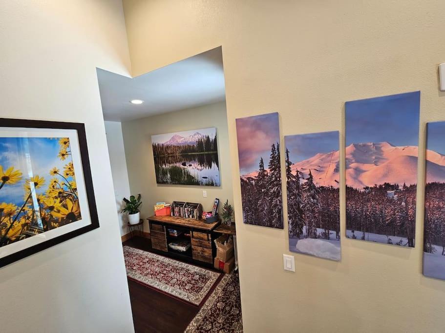a bunch of paintings on a wall in a room at Beautiful Riverfront Near Mt Bachelor with Hot Tub in Bend