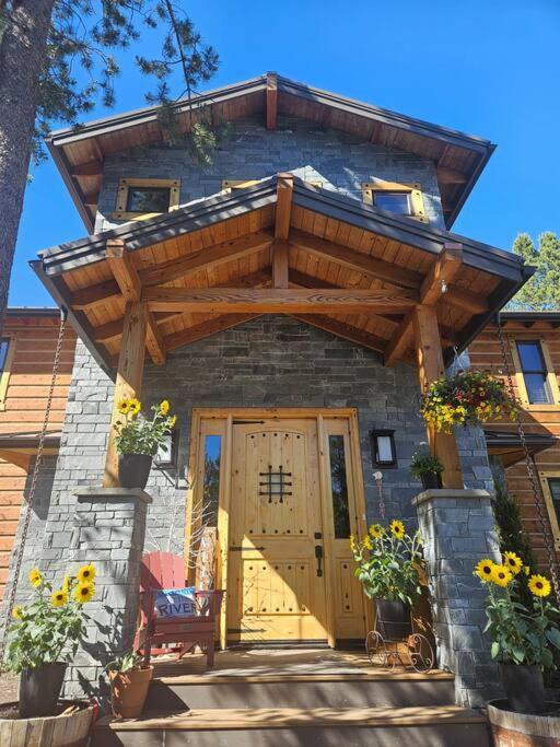 a house with a wooden door and a wooden pergola at Beautiful Riverfront Near Mt Bachelor with Hot Tub in Bend