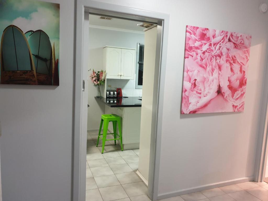 a hallway with two paintings of surfboards on the wall at Cottage BNB near the hill in Teatree Gully
