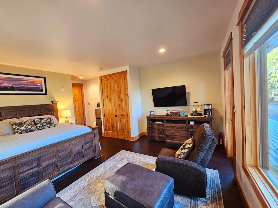 a bedroom with a bed and a flat screen tv at Beautiful Riverfront Near Mt Bachelor with Hot Tub in Bend