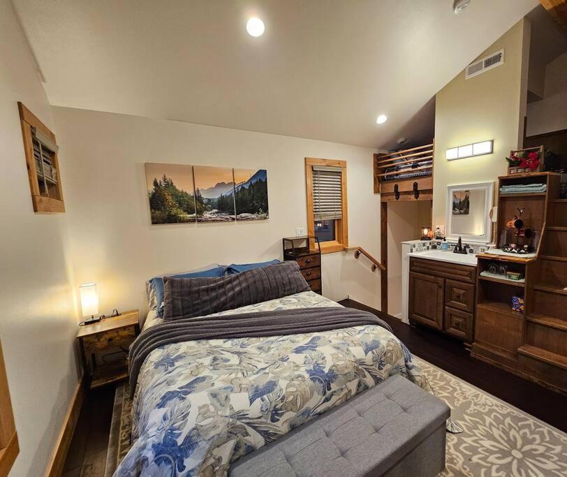 a bedroom with a large bed and a sink at Beautiful Riverfront Near Mt Bachelor with Hot Tub in Bend