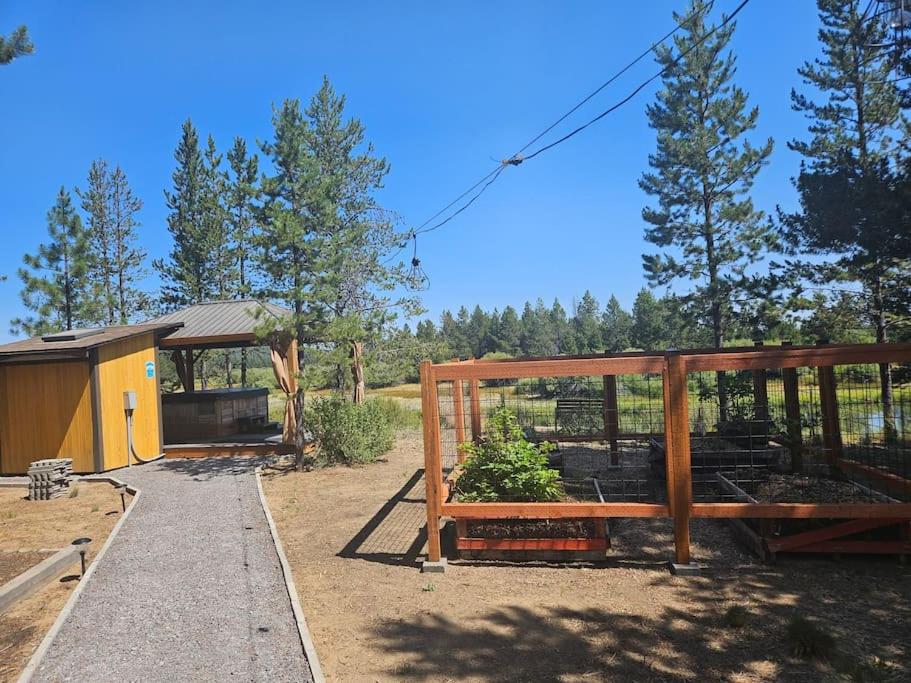 a garden with a wooden structure with plants in it at Beautiful Riverfront Near Mt Bachelor with Hot Tub in Bend
