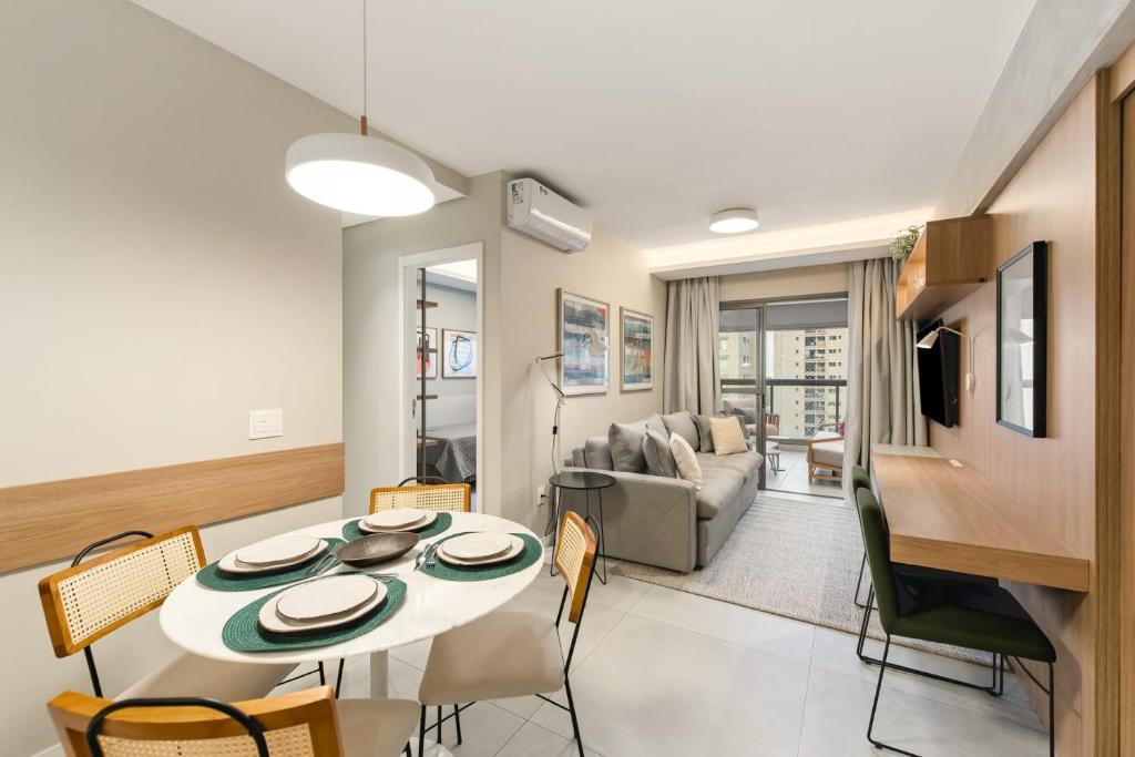 Hotel Apartamento Sensacional Novíssimo 67 mts e 2 quartos, para até 6 pessoas, a dining room and living room with a table and chairs at Apartamento Sensacional Novíssimo 67 mts e 2 quartos, para até 6 pessoas in São Paulo