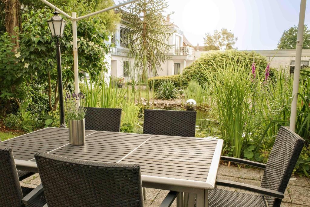 a wooden table and chairs in a garden at Appartement 1 Engel und Co in Bad Zwischenahn