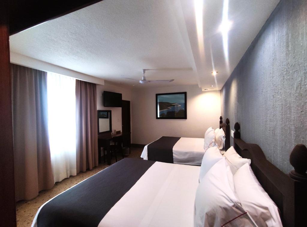 a hotel room with two beds and a window at Hotel Habana in Mexico City