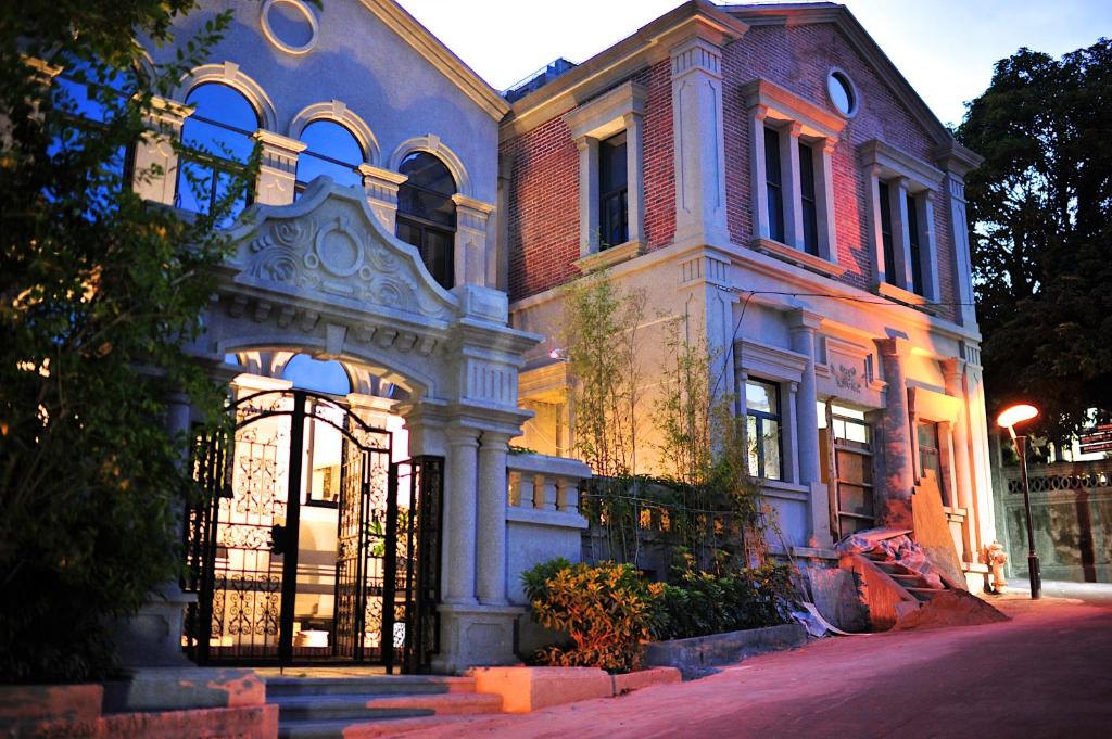 a large blue building with a gate on a street at Xiamen Gulangyu Heitan Hotel in Xiamen