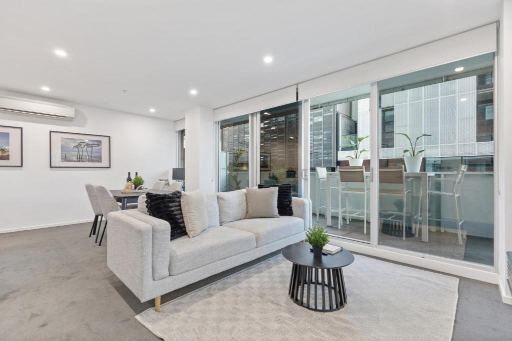 un soggiorno con un divano e un tavolo di Sleek South Yarra 2-Bed with Alfresco Dining a Melbourne