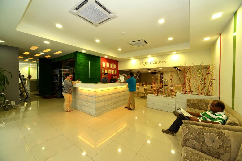 關丹的住宿－Classic Boutique Hotel Kuantan，和在柜台等候的人一起在商店大厅