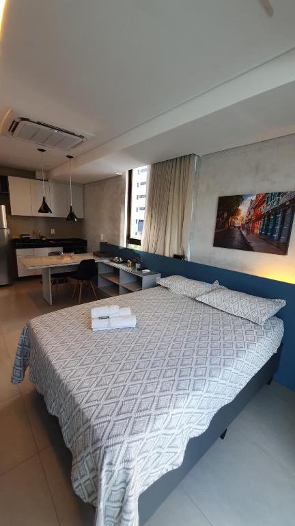 a bedroom with a large bed with a blue wall at Flat em Boa Viagem - Edifício Rooftop 470 in Recife