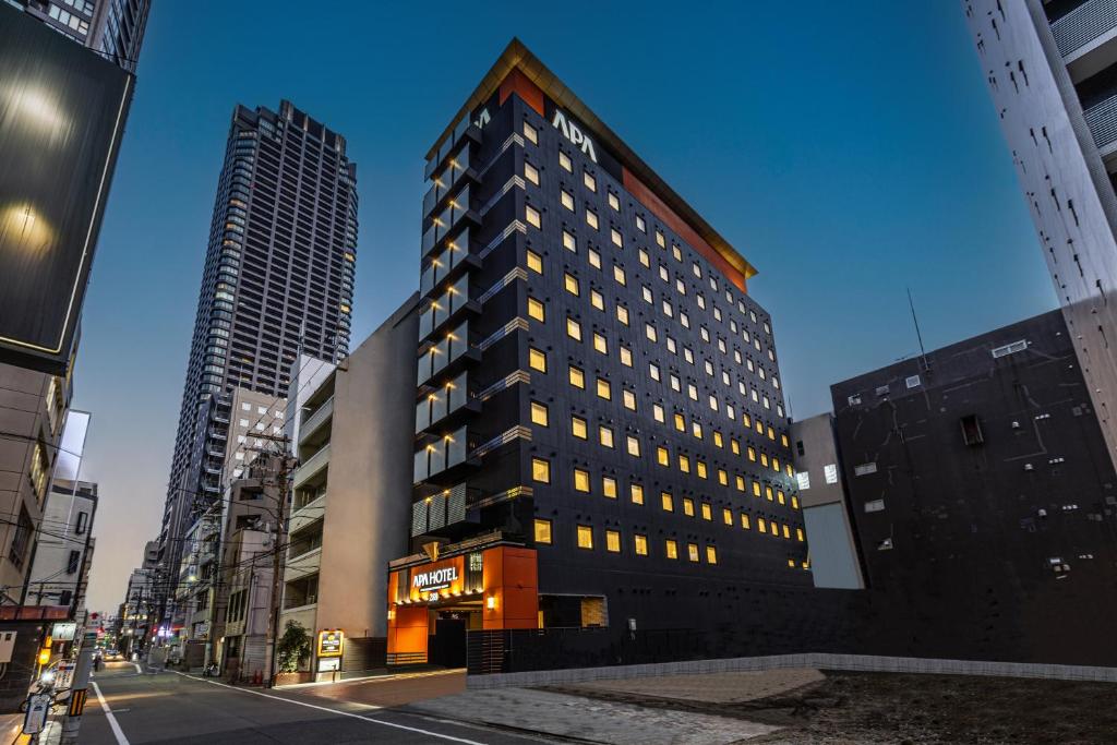 a tall building in the middle of a city at APA Hotel Yodoyabashi Kitahama Ekimae in Osaka