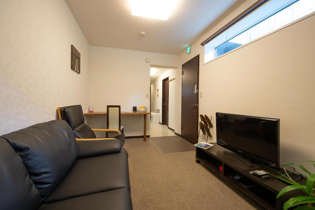 a living room with a couch and a flat screen tv at Yukon in Kutchan