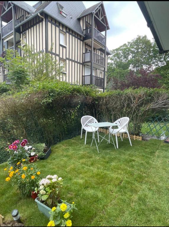 2 chaises et une table dans la cour d'une maison dans l'établissement 2p rénové Idéal famille proche de la mer, à Cabourg