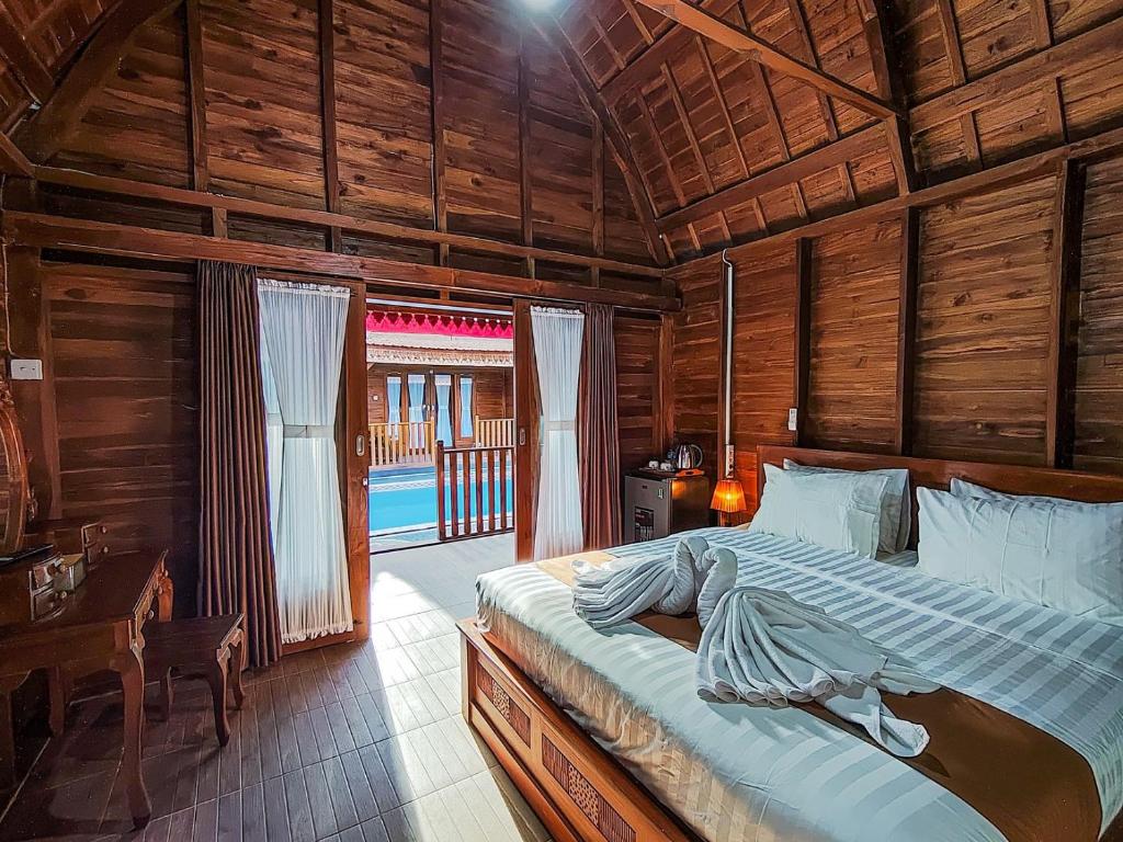 a bedroom with a bed in a wooden room at Aming Villa Balangan in Jimbaran