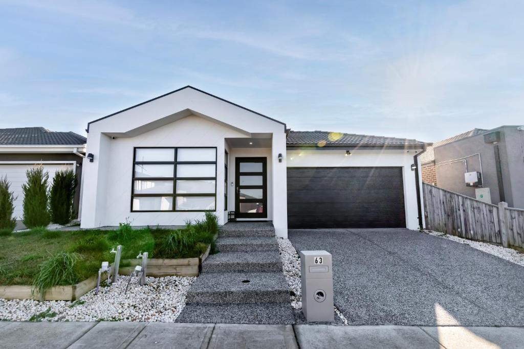 a white house with a garage at Luxury home away from home in Mickleham