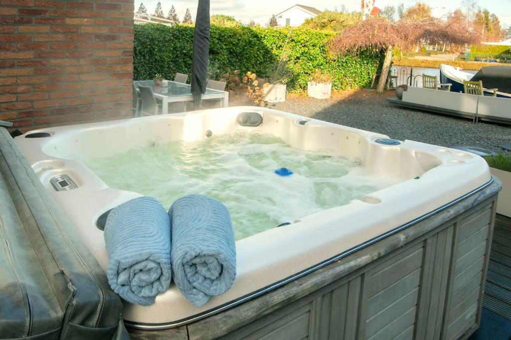 eine Whirlpool-Badewanne mit zwei Handtüchern darin in der Unterkunft Vakantiehuis aan het water in Vinkeveen