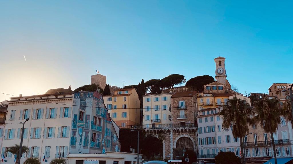 un groupe de bâtiments sur une colline avec une tour d'horloge dans l'établissement Joli 3pièces refait à neuf et très bien situé, à Cannes
