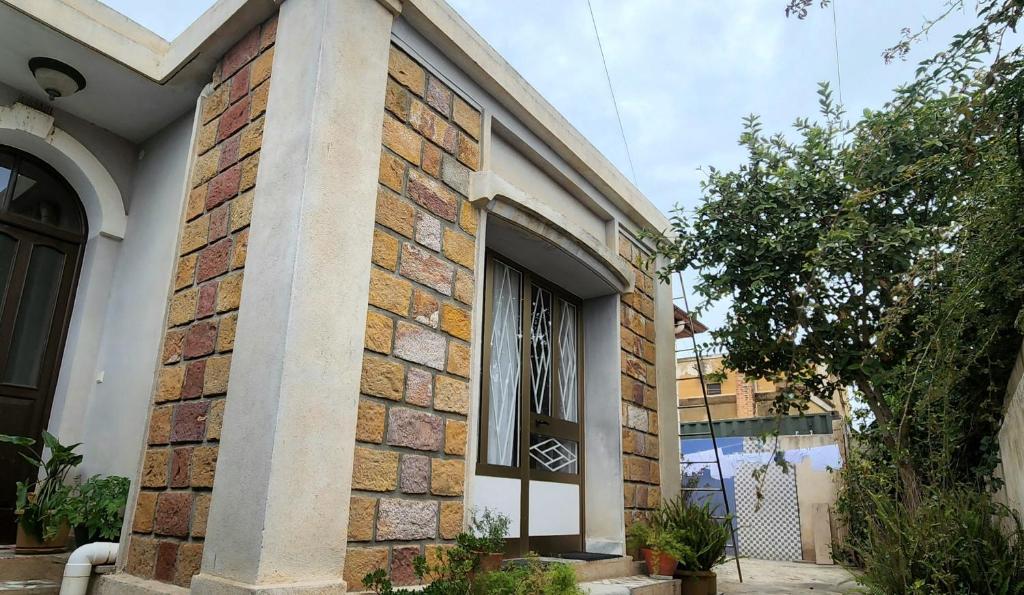 阿斯马拉Guest House in Asmera的一面有窗户的砖砌建筑