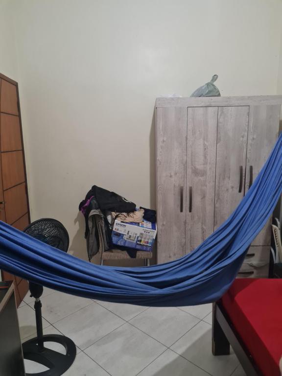 a blue hammock in a room with a bed at Delta confot hostel in São Luís