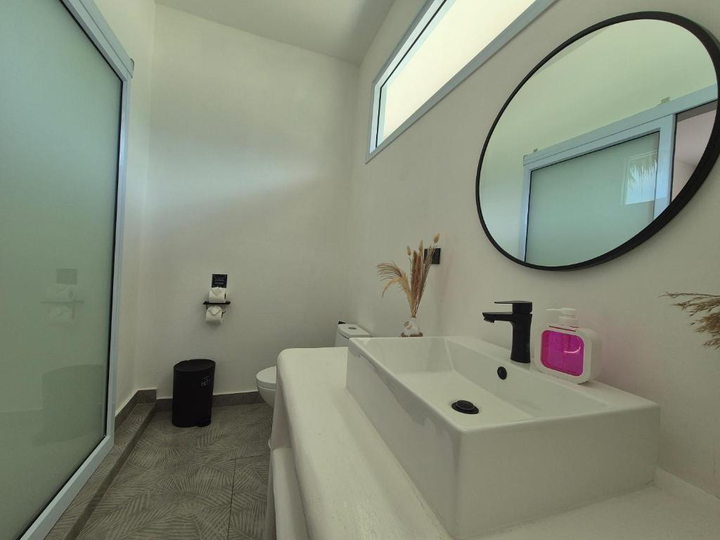 a white bathroom with a sink and a mirror at Sea Love Beach Bar & Bungalows in Ban Tai