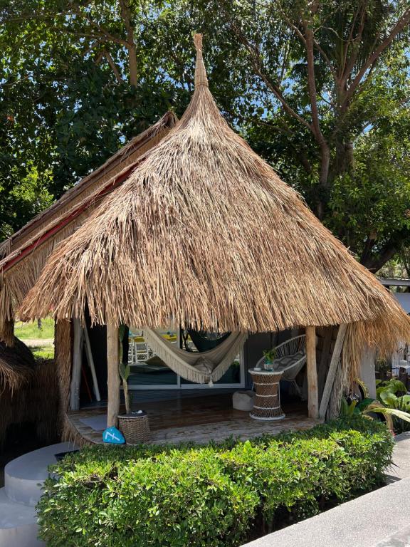 a hut with a hammock and a straw roof at Sea Love Beach Bar & Bungalows in Ban Tai