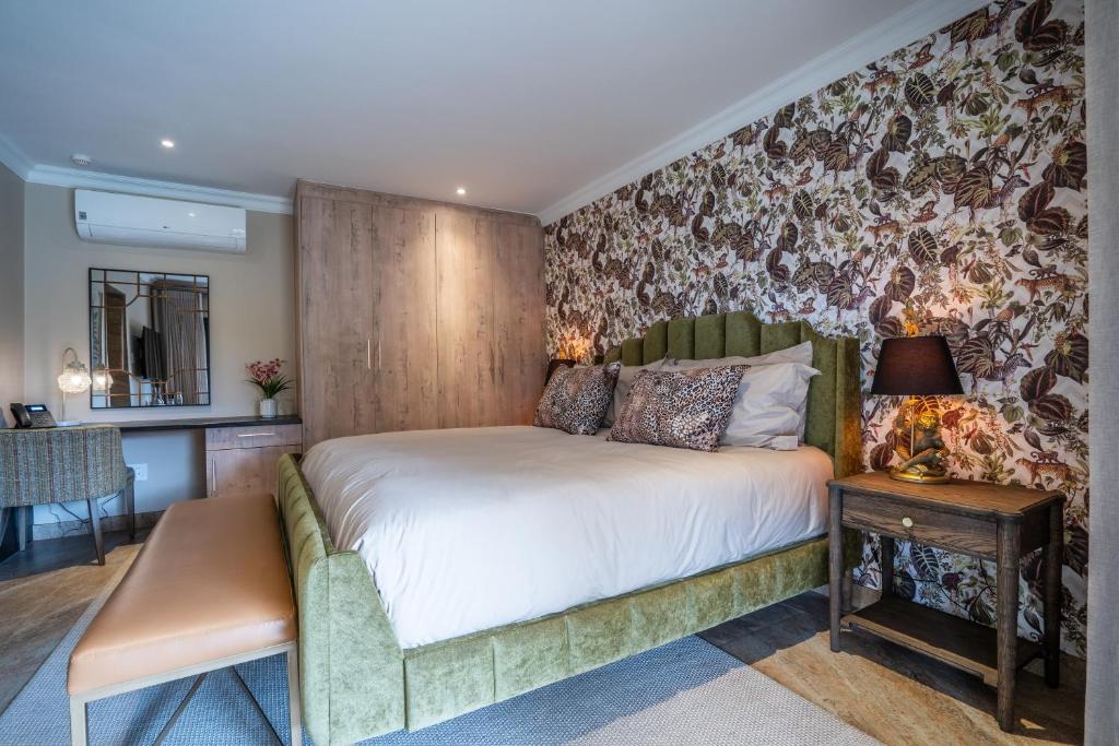 a bedroom with a large bed and a table at Lotsane Limpopo Luxury River Lodge in Sherwood