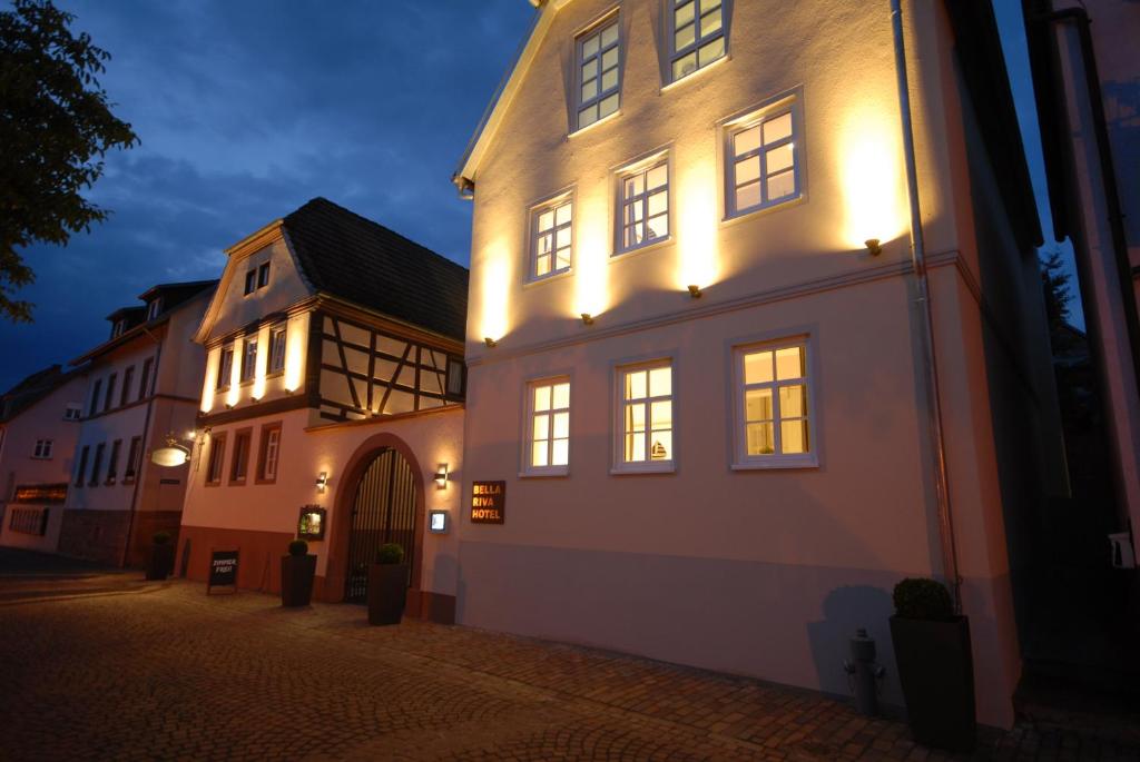 un bâtiment éclairé dans une rue la nuit dans l'établissement Bella Riva Hotel, à Marktheidenfeld