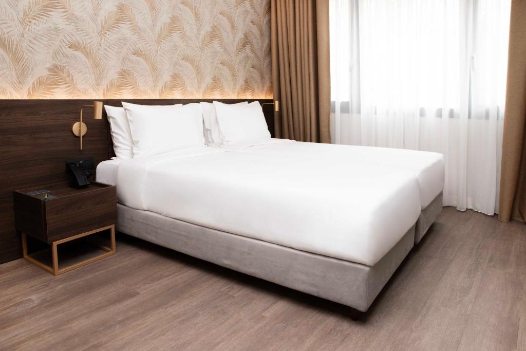 Postel nebo postele na pokoji v ubytování Luwian Athens Boutique Hotel