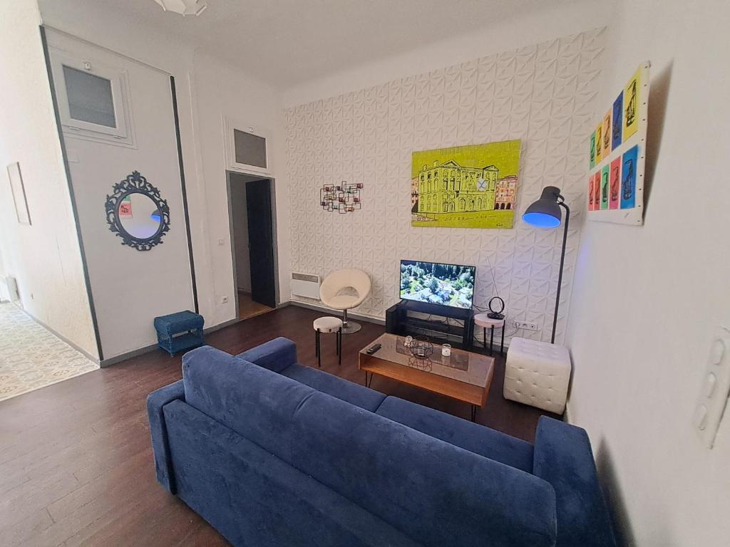 un salon avec un canapé bleu et une télévision dans l'établissement Au Méditerranéen, à Marseille