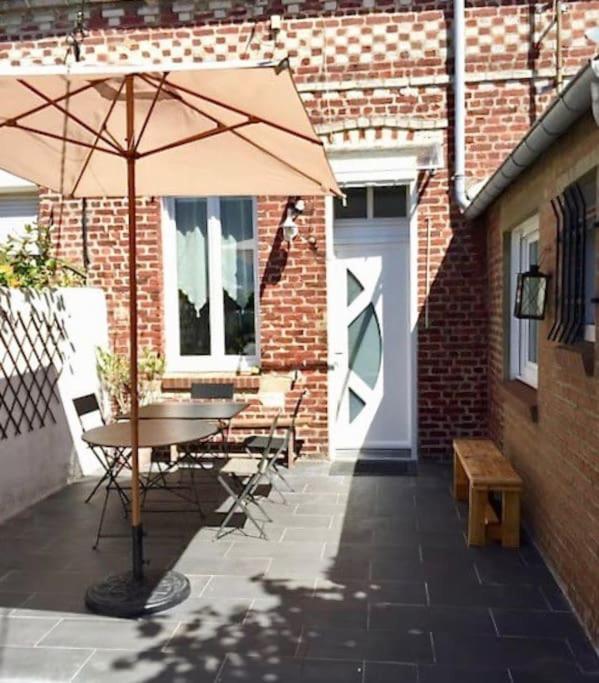 une table et des chaises avec un parasol sur une terrasse dans l'établissement maison de vacances, à Berck-sur-Mer