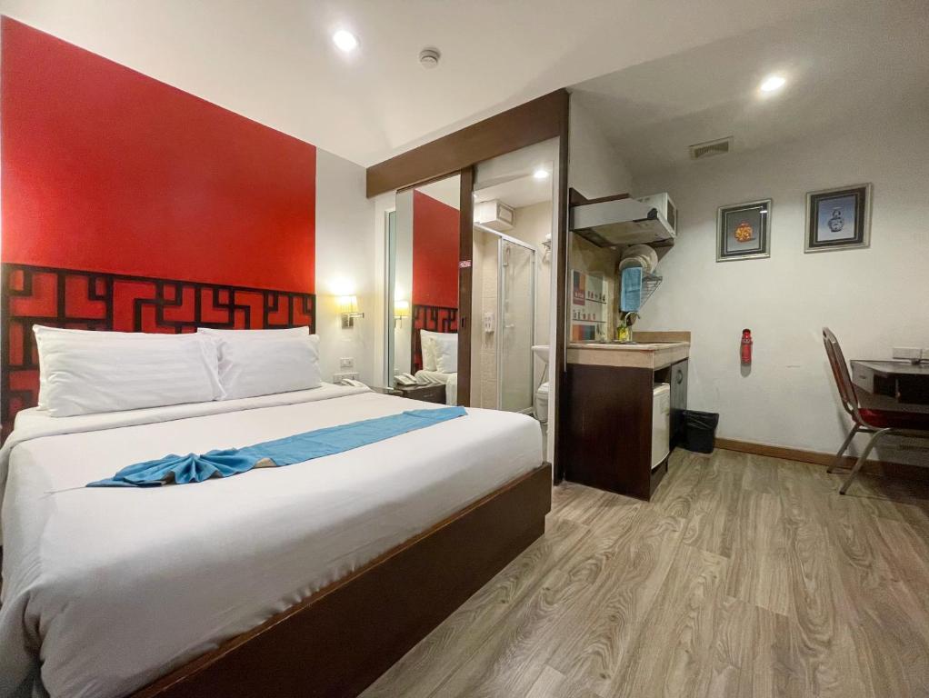a hotel room with a large bed and a desk at Arawana Express Chinatown in Bangkok