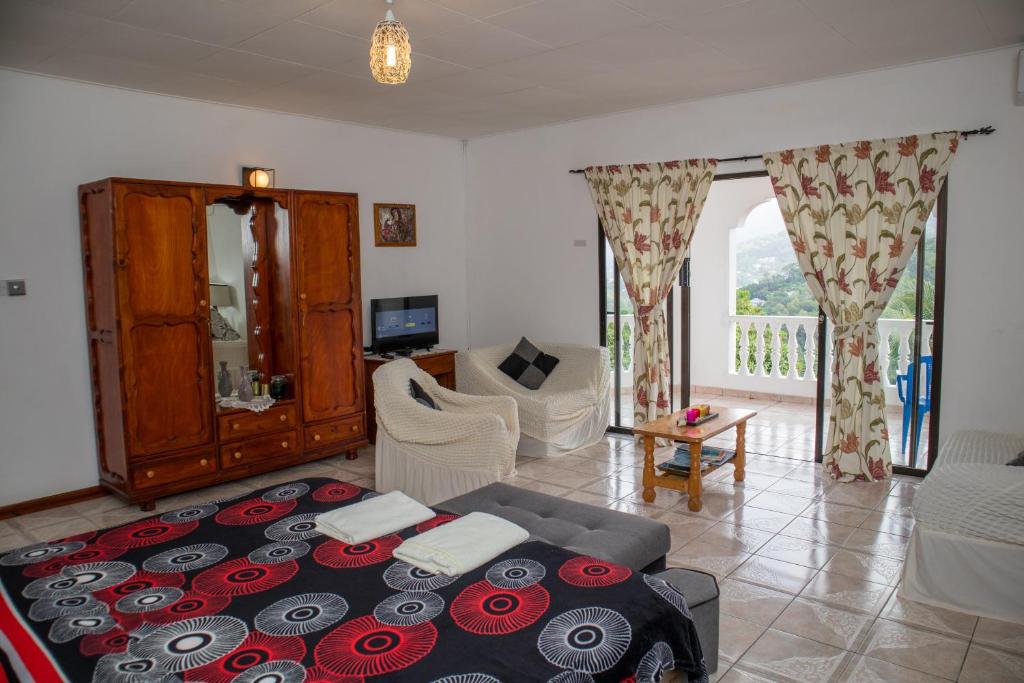 a living room with a bed and a couch at Mountain Apartments in Anse Etoile