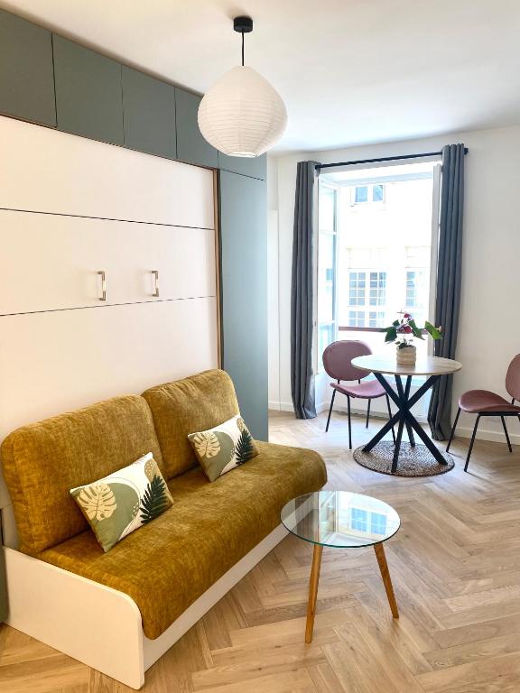 un salon avec un canapé et une table dans l'établissement Brand New Apartment - Rue Cler Paris, à Paris