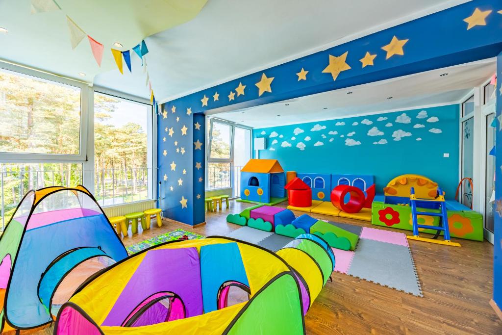 pokój dziecięcy z łóżkiem i sprzętem do zabawy w obiekcie Baltic Inn w Pogorzelicy
